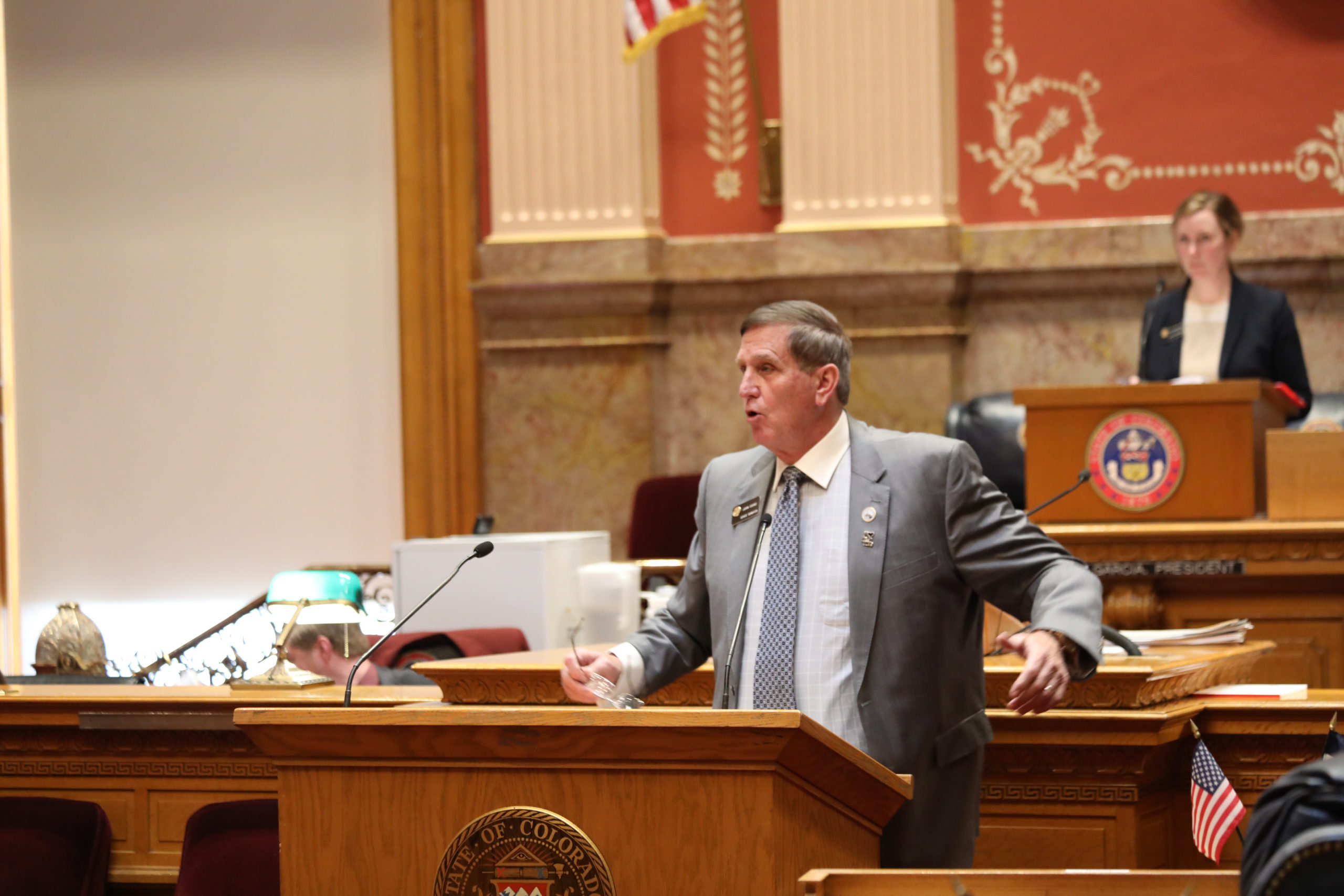 A male legislator speaking animatedly in front of the Senate