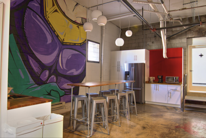 The inside of an office that is very casual with a purple and yellow mural on the wall The inside of an office that is very casual with a purple and yellow mural on the wall
