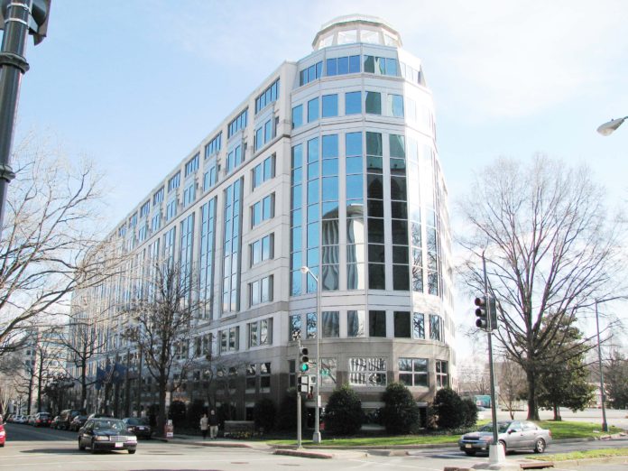 A large building of glass that has a rounded top and is long