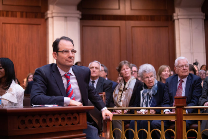 Attorney General Phil Weiser sitting at a table in a court room Attorney General Phil Weiser sitting at a table in a court room