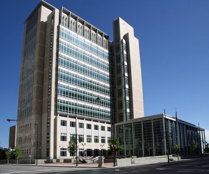 A tall building with many windows against a blue sky background