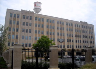 EEOC’s Pay Data Reporting Deadline Approaches A large rectangular service warehouse surrounded by black metal fencing