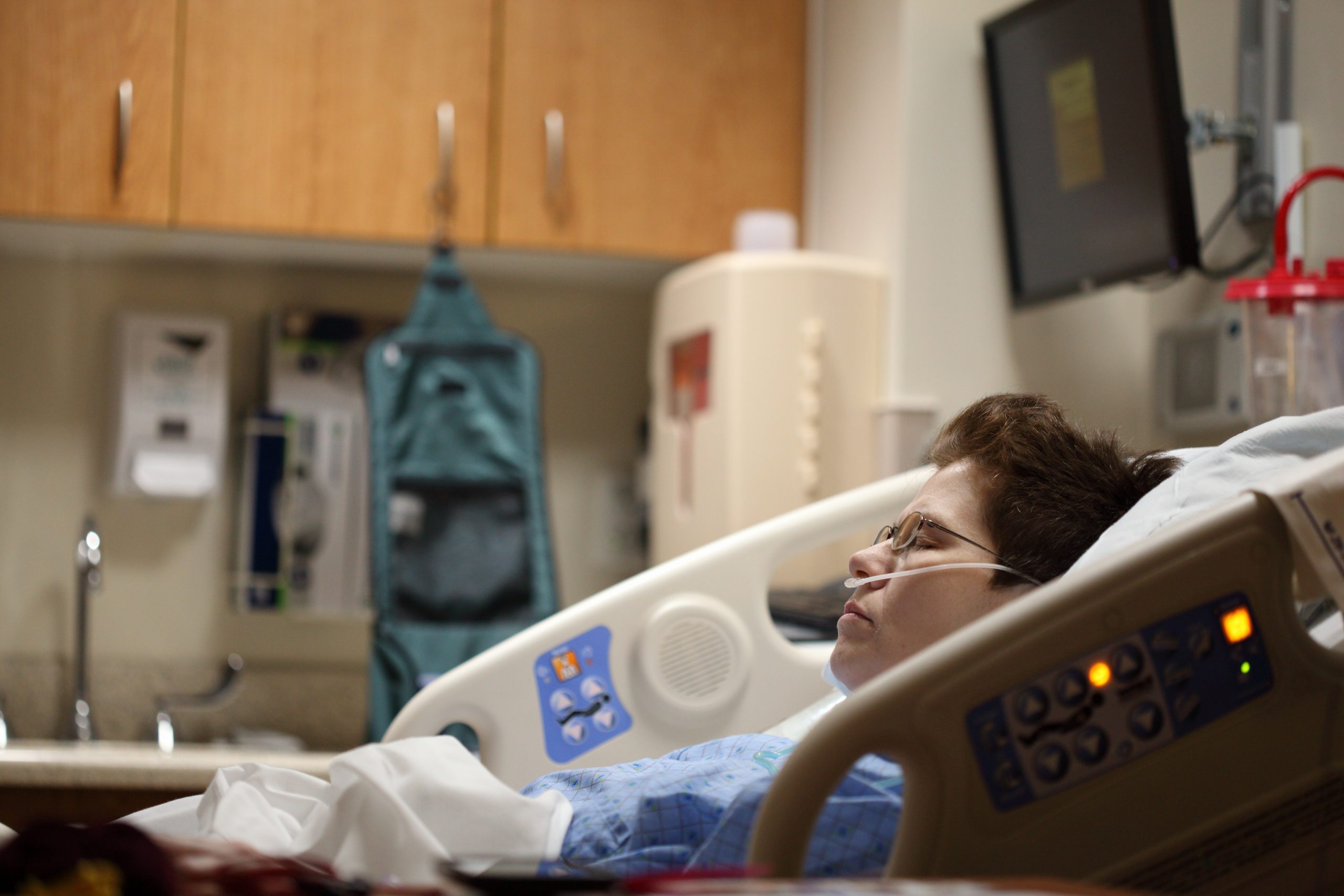 A young terminally ill person in a hospital bed