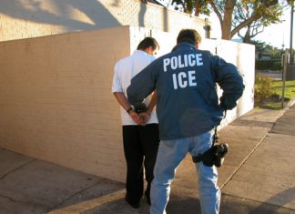 House Considers Immigrant Legal Defense Fund An Immigration and Custom Enforcement Officer arresting a man in a white shirt