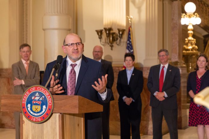 Colorado Supreme Court Justice Carlos Samour speaks behind a podium Colorado Supreme Court Justice Carlos Samour speaks behind a podium
