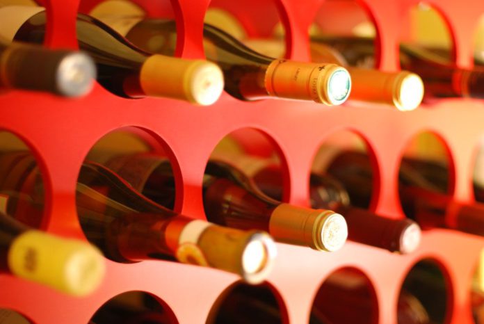 Wine bottles laying down stacked in circular holes