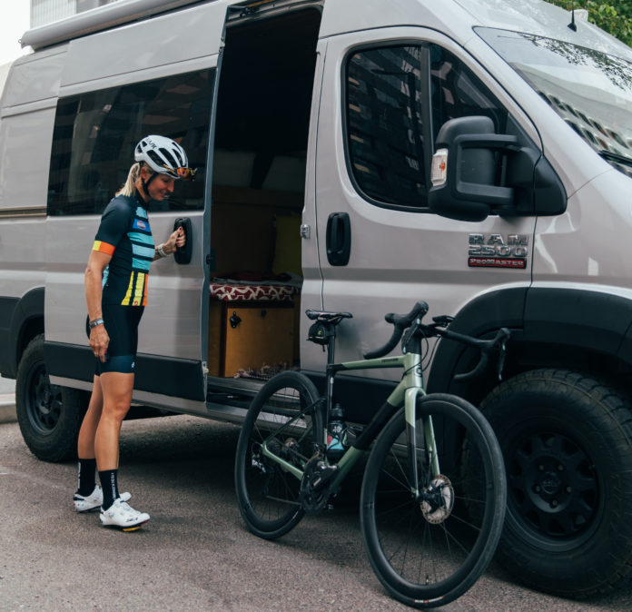 Megan Hottman stands with her bike outside of her van dubbed 