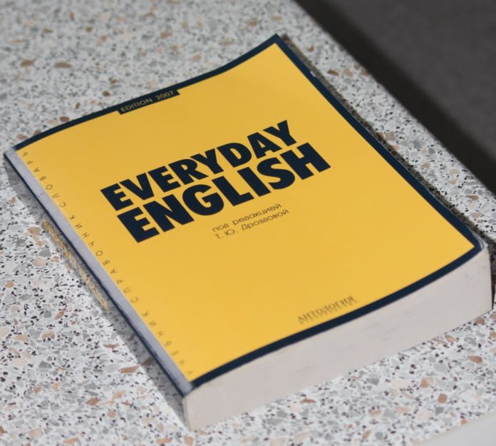 A book title Everyday English sits on a desk