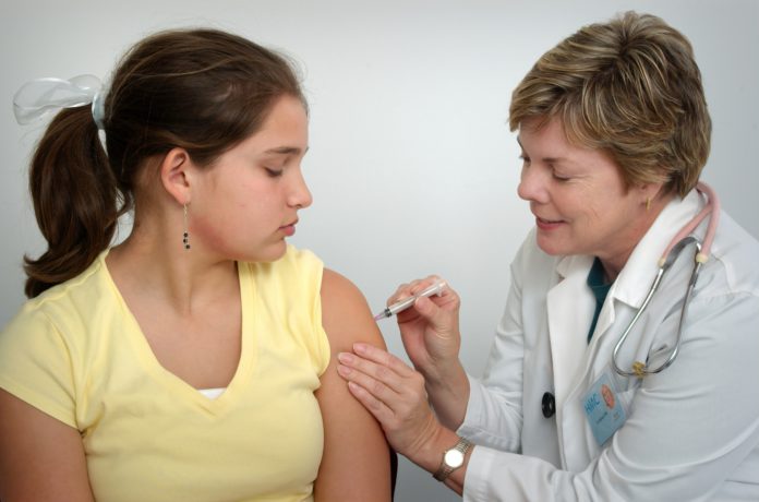 Girl getting a vaccine from a health professional