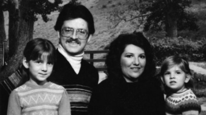 The Bennett Family sits smiling for a black and white portait.