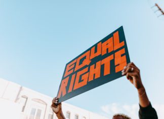 Colorado’s First Steps Toward Equality, a Continuing Effort A protestor holds a sign high that reads "equal rights."