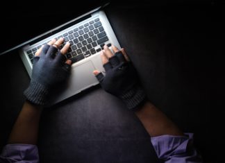 Jamaican National Sentenced for $970k Lottery Scam of Estes Park Woman hands over a laptop