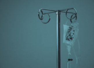 Loveland Clinic to Pay $40K for Marketing Animal Anti-Parasite Drug as COVID Cure an IV stands alone in a low-light room