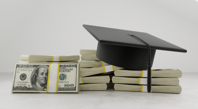 Graduation cap sitting on a stack of cash