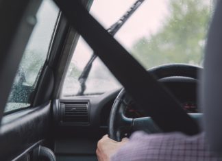 Click It or Ticket – the Origins of Seat Belt Laws in Colorado A seat belt is crossed over a driver who is holding the steering wheel steady.