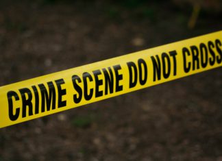Nearly 20 Years Later, Denver Murder Case Gets Fresh Eyes Bright yellow crime scene tape is in focus with a dark, murky background