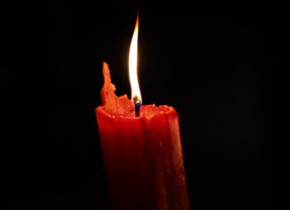 Cult Leader’s Death Still Undetermined, Charges Dropped Against Members The flame of a red candle flickers in the darkness