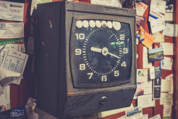 photo-1619995743614-5608bea411b3 An old punch-in clock for employee timecards