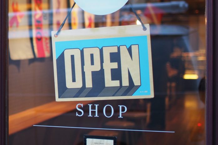 Open sign hanging on glass door