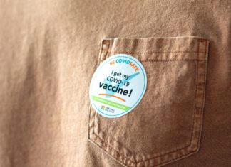 White House Announces Details of OSHA, Health Care Worker Vaccine Rules A shirt with a sticker that says "I got my COVID-19 vaccine!"