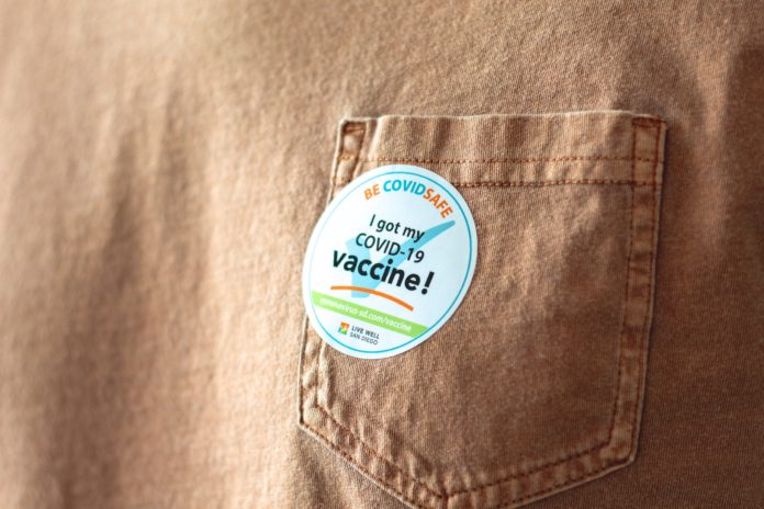 marisol-benitez-OY8KhPCT3V8-unsplash A shirt with a sticker that says "I got my COVID-19 vaccine!"