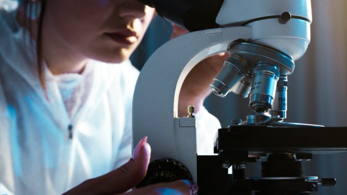 Woman looking through a microscope