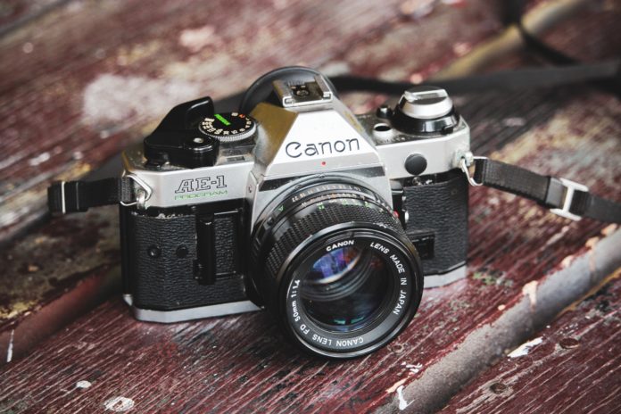 a 1980s camera sits on old wood planks