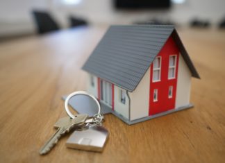 Western ‘Zoom Towns’ Take Aim at Short-Term Rentals a house key sits on a table next to a miniature model of a home