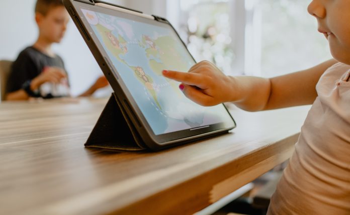 Child using tablet for remote learning