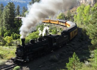 Civil Action Against Historic Railroad for 416 Fire Closes Following Federal Settlement A coal train towing passenger train cars in the mountains