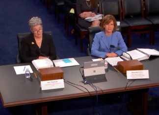 Federal Judges Request Funds to Keep Up With Security Risks, Growing Workload and Other Concerns A woman with short white hair in a black suit sits to the left of a woman with short brown hair in a light blue suit in front of a large table.