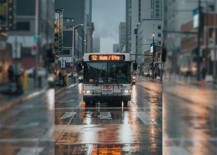 a Denver RTD bus drives toward a rainy intersection