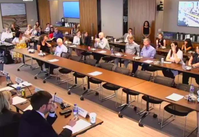 A birds eye view of a conference room hosting a panel and audience.