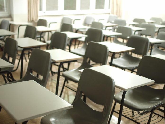 An empty classroom filled with desks for students.