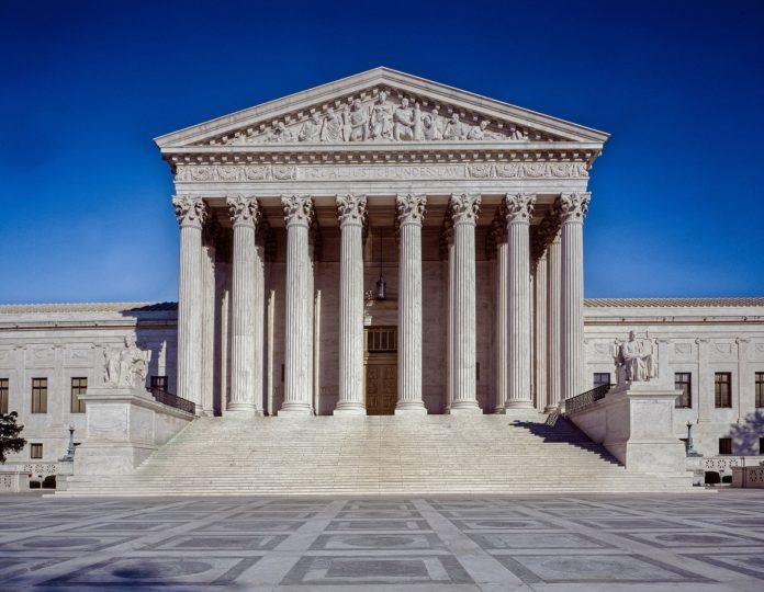 The U.S. Supreme Court building. A large white building with pillars and a high set of stairs.