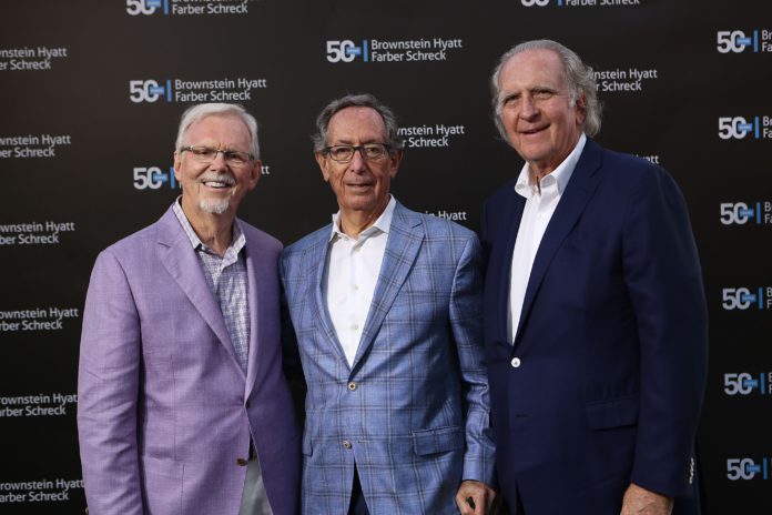 Three men wearing suit coats stand in front of a black background which reads in different locations Brownstein Hyatt Farber Schreck with the number 50 next to it.