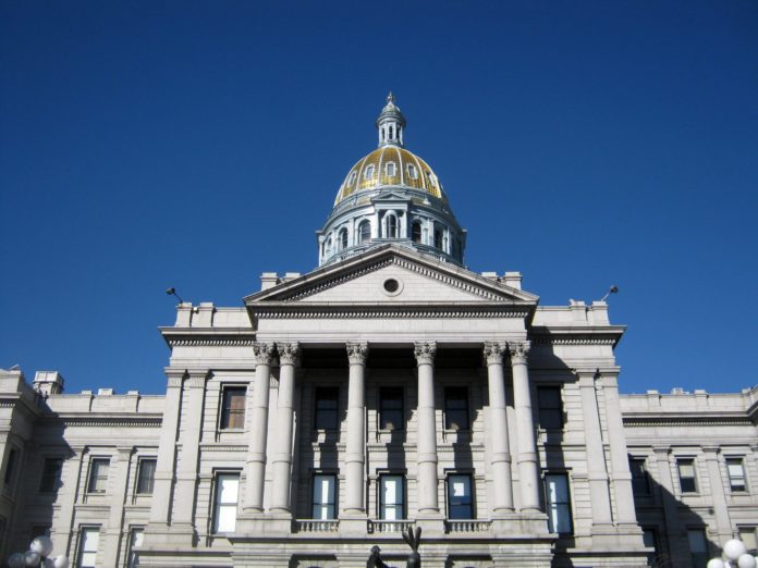 An image of a large concrete building with multiple pillars in front. The top of the building is a dome.