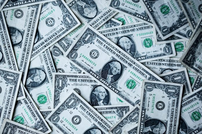 alexander-grey-8lnbXtxFGZw-unsplash Multiple one dollar bills are strewn about in a pile
