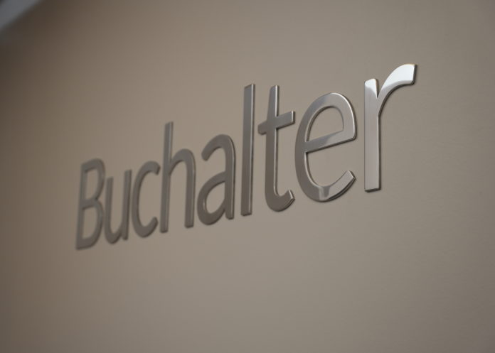 BuchalterDenver Silver chrome letters on a white wall spell out Buchalter.