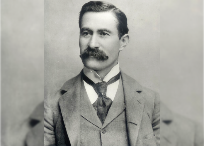 Casimiro Barela sits for a photo in roughly 1910. He has a fashionable suit, vest and tie on and an impressive mustache. His hair is short and neatly combed and it looks like he may be smiling slightly.