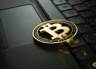 Cryptocurrency Businesses Could Have Easier Time Securing Loans in Future A gold coin has a “B” in the middle of it with two lines going through it which rests on a laptop keyboard. It reads “Bitcoin” on the bottom of the coin.
