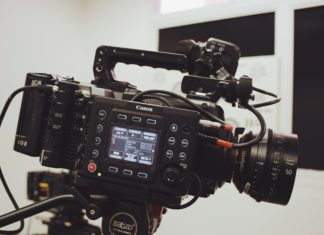 TV and Film Portrayals: How They Impact the Legal Profession An image of a black video camera with a screen on the camera showing different numbers. Cords are connected all over the camera.
