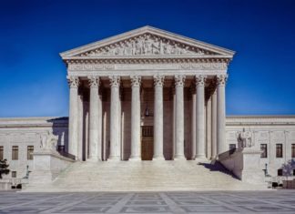 Supreme Court to Hear Civil Forfeiture Appeal A white building with seven pillars in front with a peaked concrete roof has steps coming up to it. Statues of a person sitting in a chair are seen on both arms of the stairs.