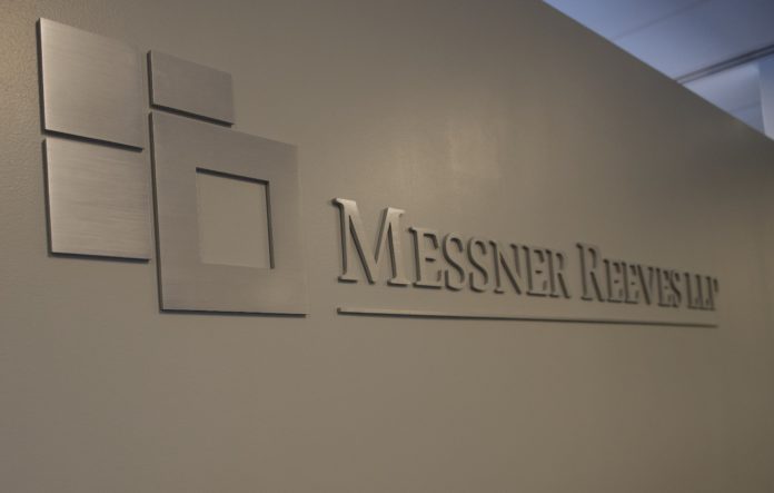 A silver brushed chrome logo that reads Messner Reeves on a white wall.
