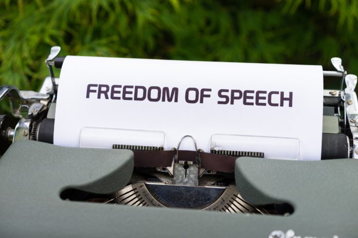 A typewriter has a piece of paper in it with the words “Freedom of Speech” spelled out.