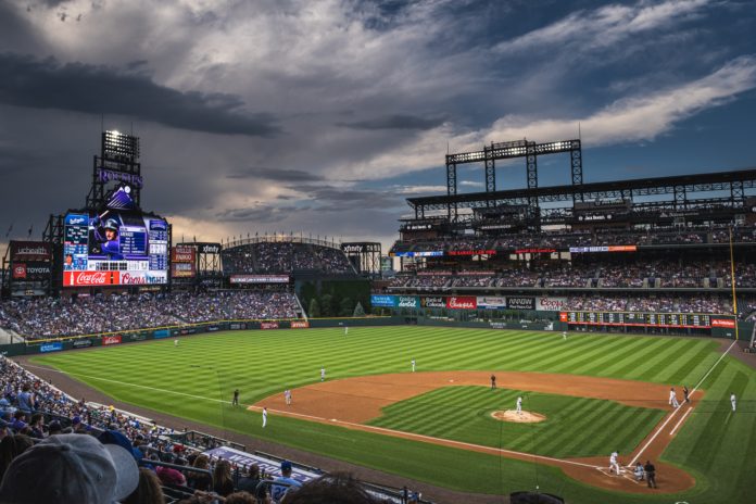 A thunderstorm is brewing over Coors Field during a Colorado Rockies game.