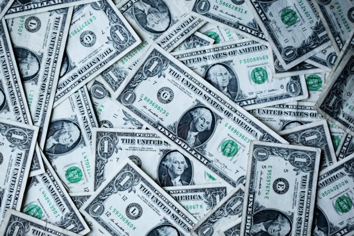 alexander-grey-8lnbXtxFGZw-unsplash One dollar bills are strewn about.