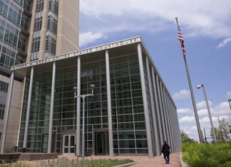 Federal Pro Se Clinic Launches Pilot Program for Colorado Prisoners A modern looking courthouse with letters on the top that read “Alfred A. Arraj United States Courthouse.” The courthouse has glass on the front of the building and six light gray pillars in front. In front of the courthouse is a small courtyard with benches and wildflowers. To the right of the courthouse a woman walks towards the door and there’s a flagpole with the American flag.