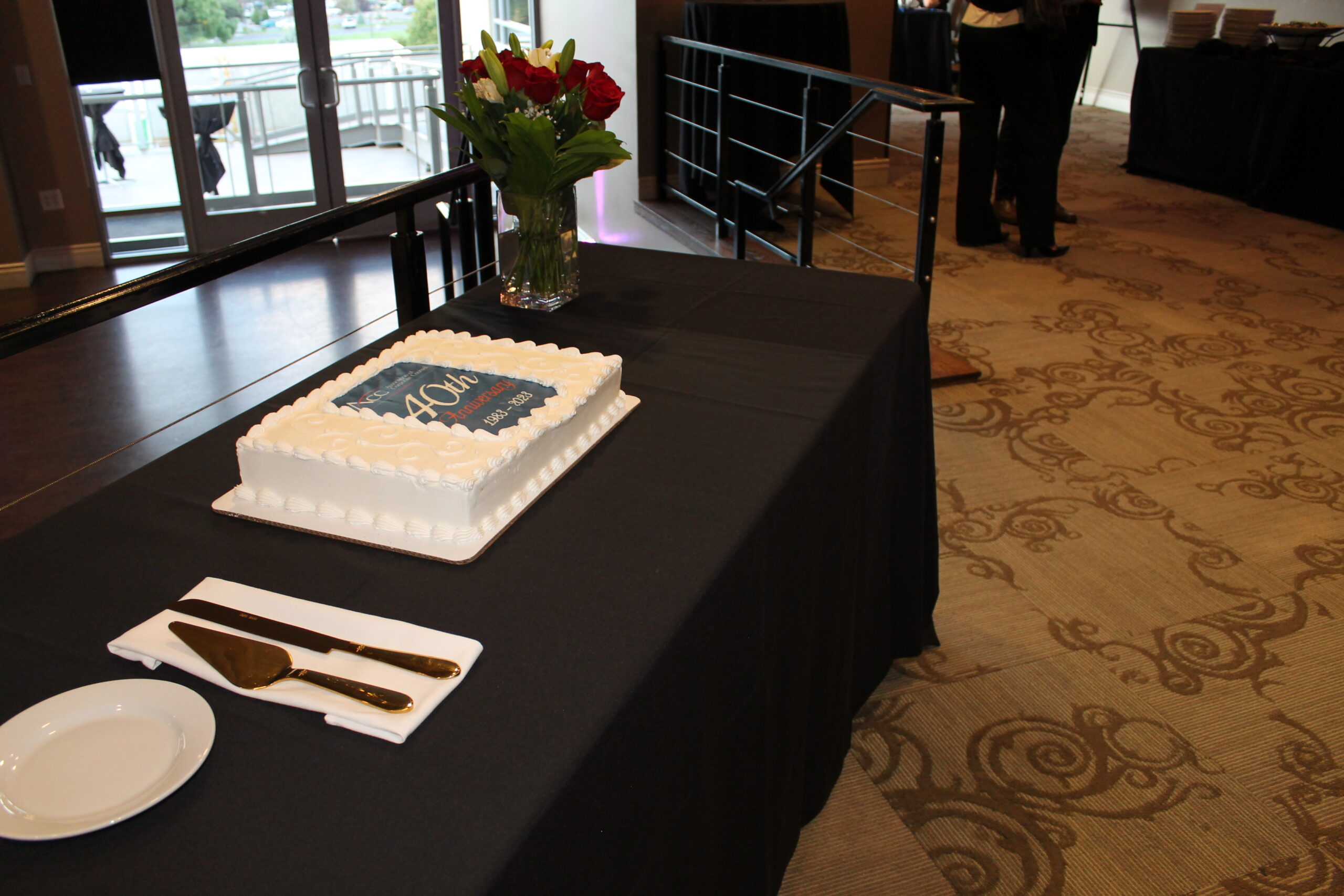 a sheet cake sits on a table with serving knives to the side