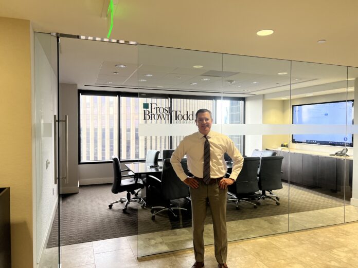 Managing Partner of Frost Brown Todd's Denver office stands in front of the new office's conference room.